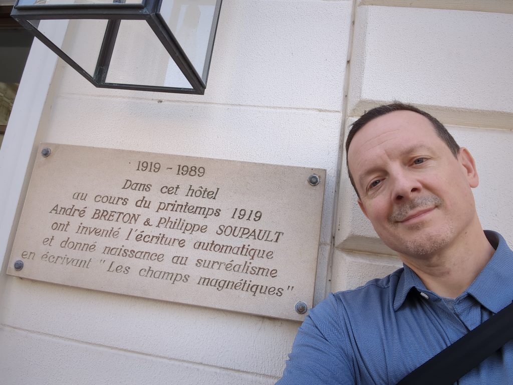 The author, Nick Montfort, standing in front of a plaque commemorating the birthplace of surrealism. 