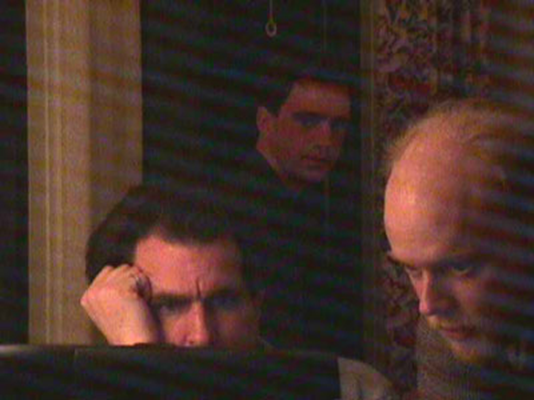 bald men sitting around a computer, taken on an old digital camera